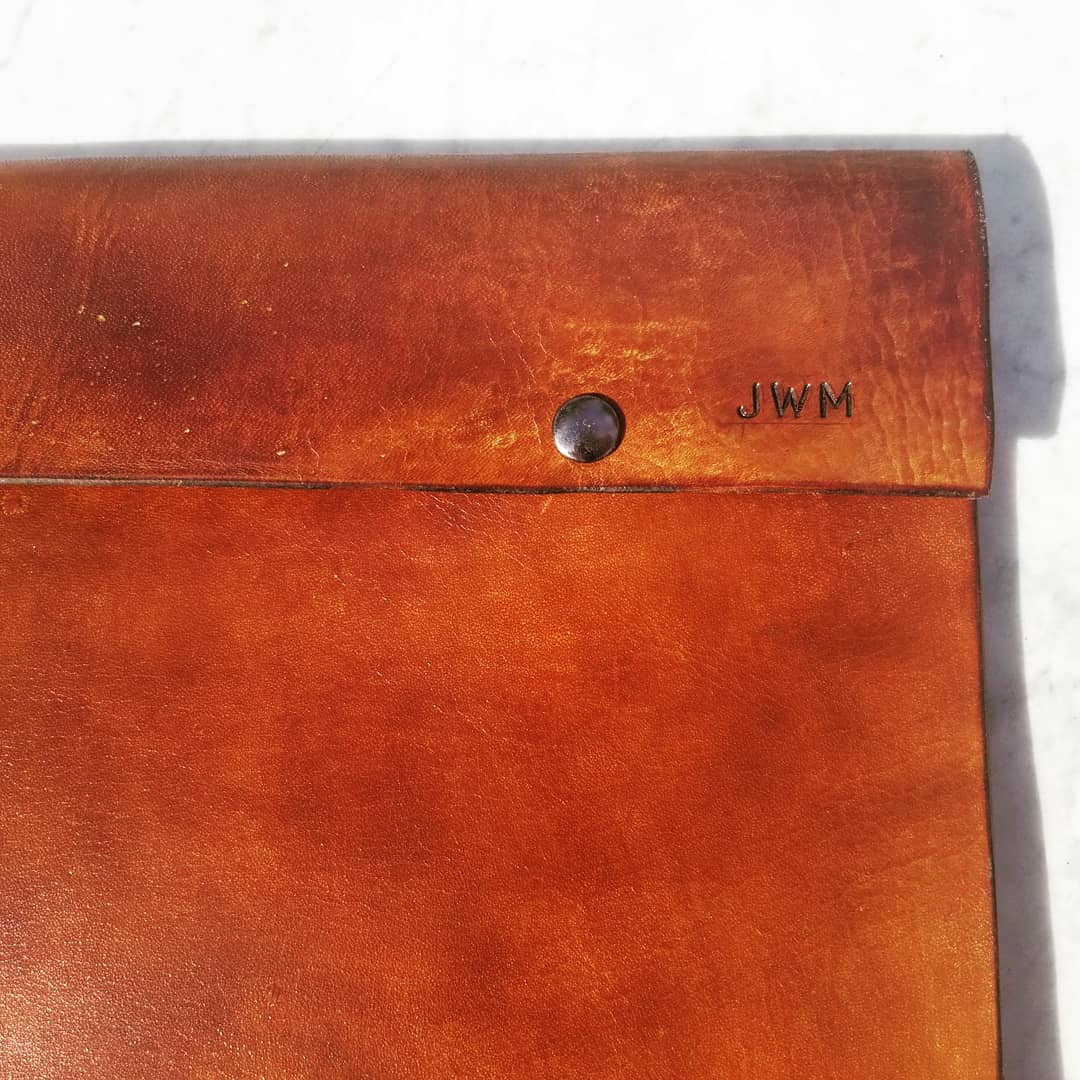 Close view of the JWM monogram on the leather portfolio