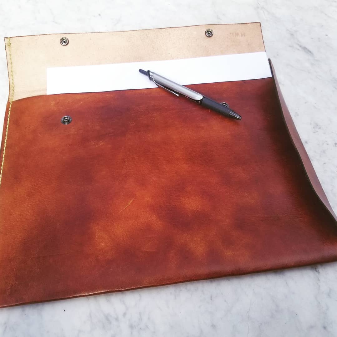JM IV handmade leather portfolio open with paper and a pen